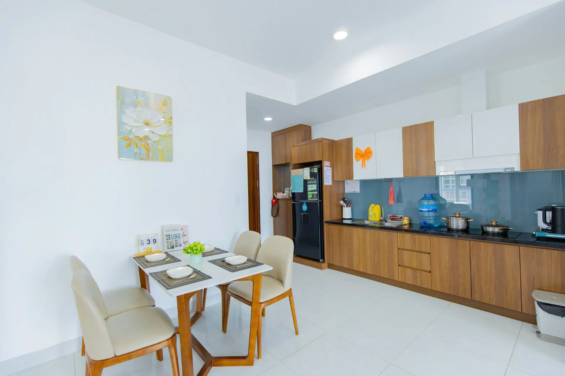 Gian bếp gia đình đầy đủ bếp từ, nồi chảo và bát đĩa tự nấu hải sản — Căn Hộ 1006